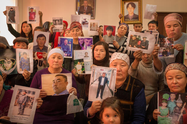 Dans les locaux de l'association Atajurt, des familles brandissent le portrait de leurs proches retenus ou détenus dans le Xinjiang. Almaty, Kazakhstan, décembre 2018.