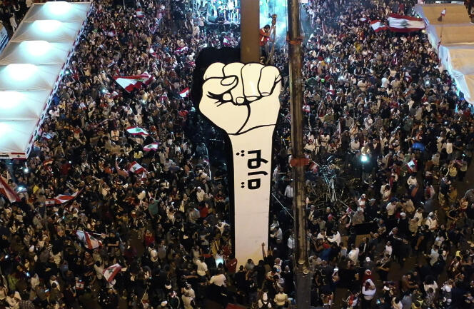 Des manifestants brandissent le « Poing de la Révolution », symbole de la contestation antigouvernementale, sur la place des Martyrs, à Beyrouth, le 22 novembre.