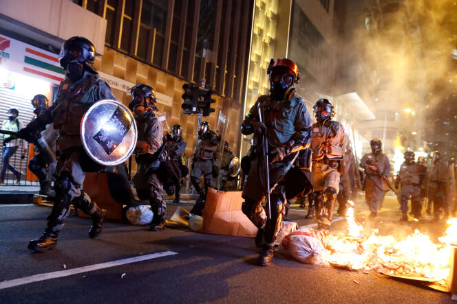 Des policiers franchissent une « barricade » de feu, lors d’une manifestation pour l’autonomie du territoire hongkongais, le 2 novembre 2019.