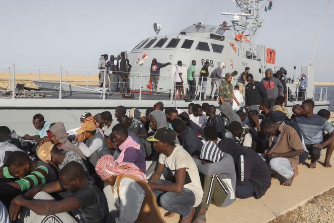Des migrants secourus attendent devant un bateau des gardes-côtes dans la ville de Khoms, dans le nord-ouest de la Libye, le 1er octobre 2019.