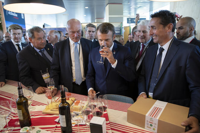 Emmanuel Macron, accompagné du président de la Nouvelle-Aquitaine, Alain Rousset (à gauche), goûte des produits locaux, à Anglet, le 24 août.