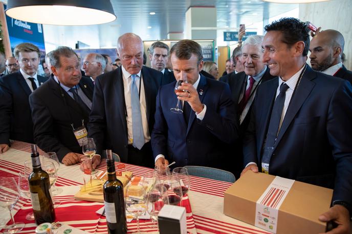 Emmanuel Macron, accompagné du président de la Nouvelle-Aquitaine, Alain Rousset (à gauche), goûte des produits locaux, à Anglet, le 24 août.