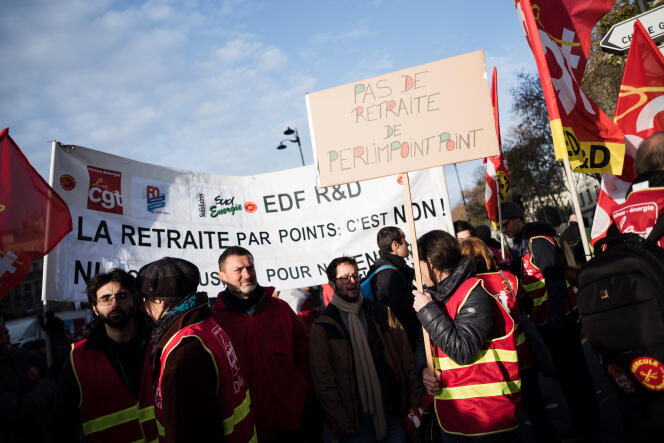 Une manifestante de la CGT EDF R&D tient une pancarte sur laquelle est écrit « pas de retraite de perlimpoint point », à Paris, le 10 décembre.