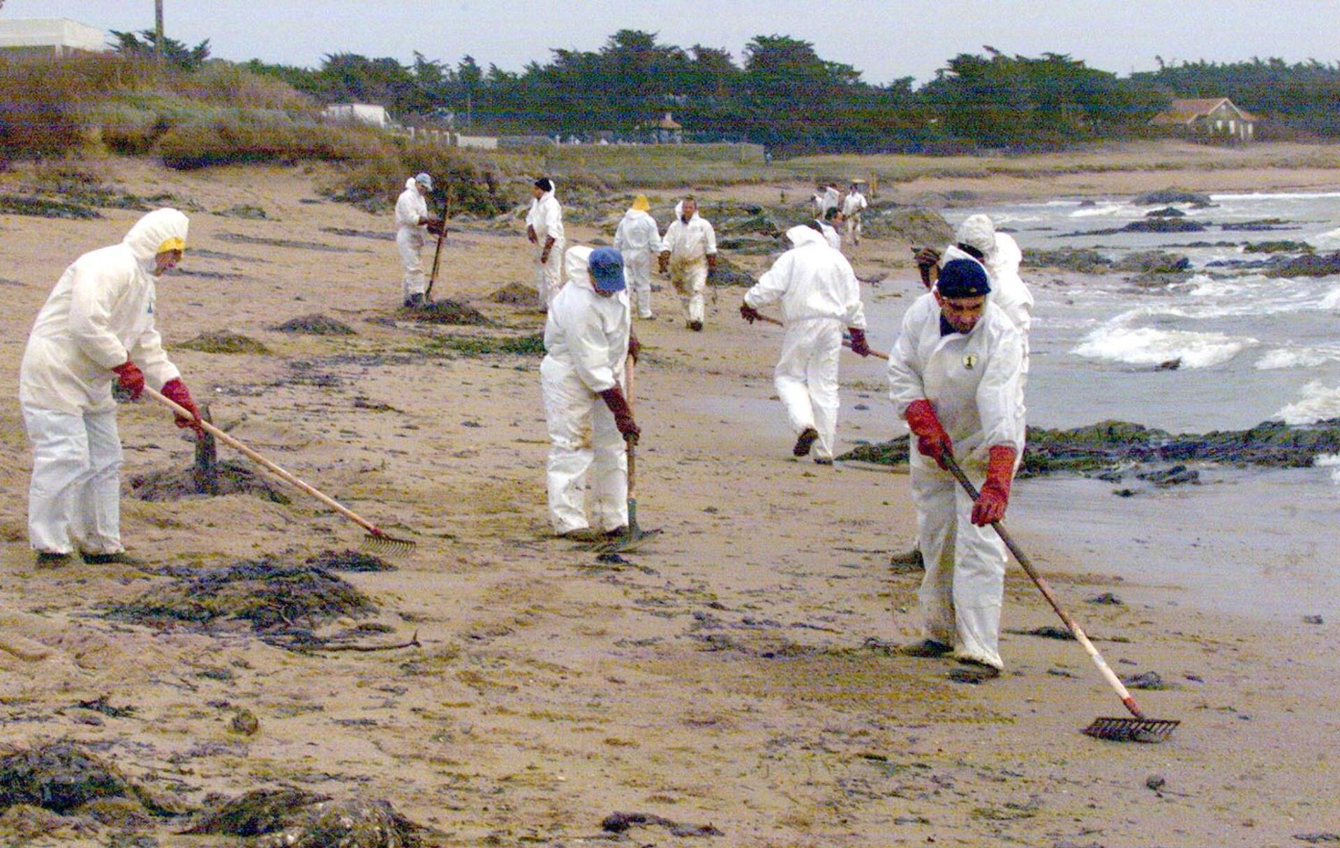 Des bénévoles de la ville de la Roche-sur-Yon (Vendée) nettoient, le 4 Janvier 2000, la grande plage de la Herbaudière, sur l'île de Noirmoutier.