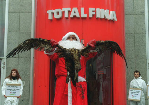 Un membre de Greenpeace, habillé en Père Noël, présente, le 27 décembre devant le siège de la firme pétrolière Totalfina à la Défense, un cormoran mazouté par la marée noire des côtes atlantiques provoquée par le naufrage du pétrolier.
