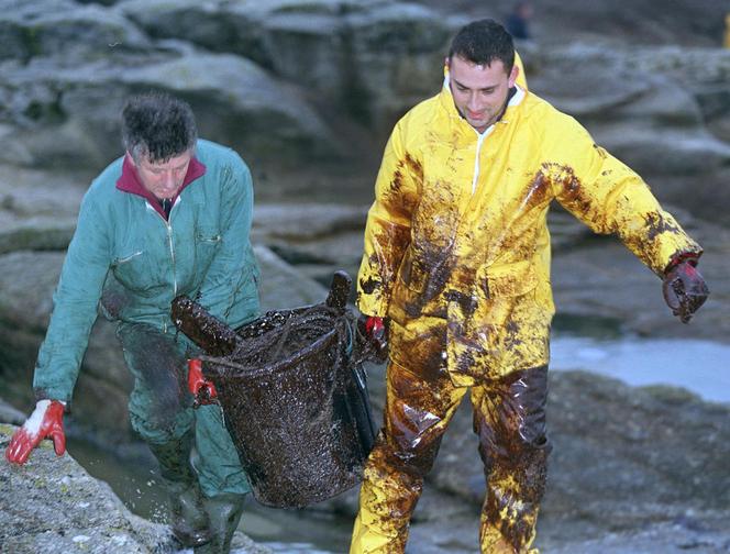 Pessoas limpam a praia de Ploemeur (Morbihan), após o naufrágio do petroleiro “Erika”, 26 de dezembro de 1999.