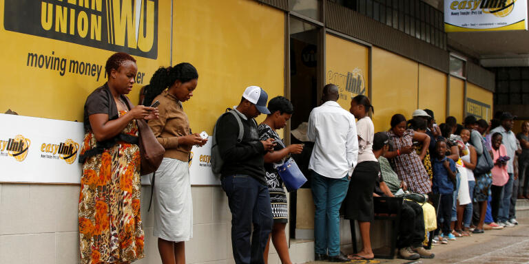 Zimbabweans queue outside a Western Union branch in Harare, Zimbabwe, February 26, 2019. REUTERS/Philimon Bulawayo - RC16ACF17C00