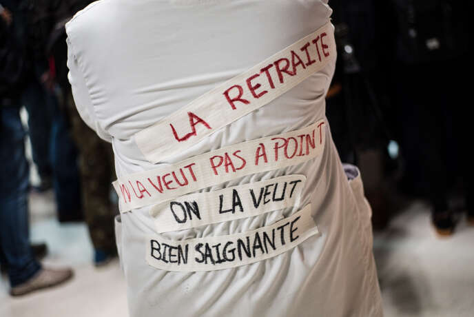 Des figures de la gauche viennent saluer les grévistes de la Gare de Lyon, à Paris. Sur sa blouse, dans son dos, une soignante a inscrit 