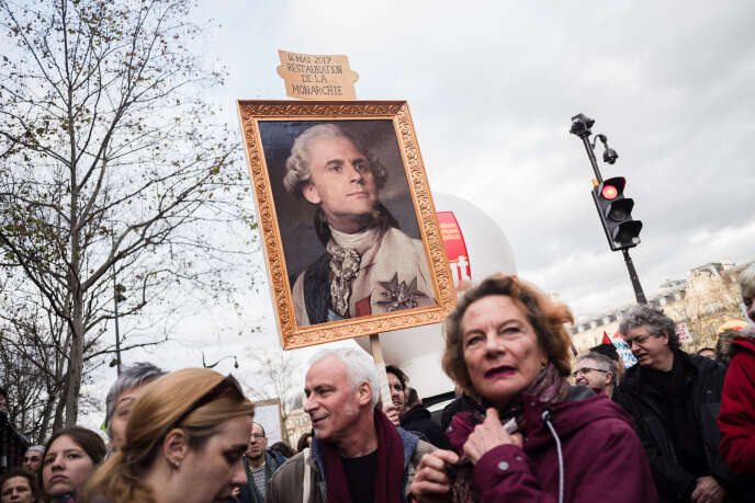 Troisieme journee de mobilisation contre la reforme des retraites. Un homme tient un pancarte represantant un tableau d Emmanuel Macron en monarque et lisant 