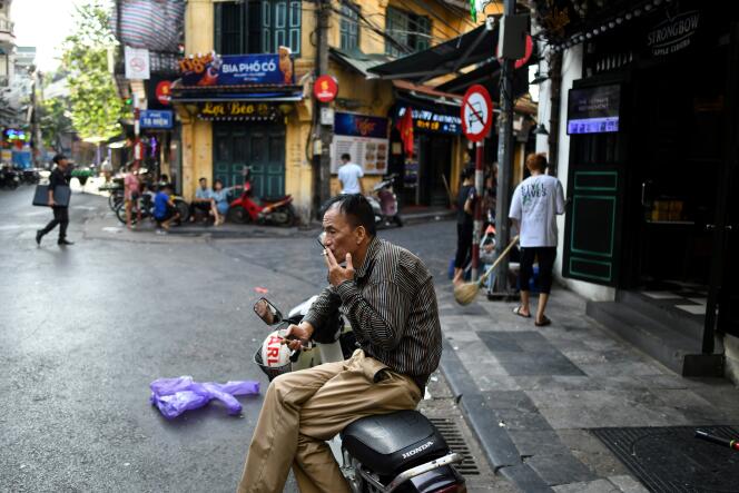 Un homme fume une cigarette dans une rue de Hanoï, au Vietnam, le 3 septembre.
