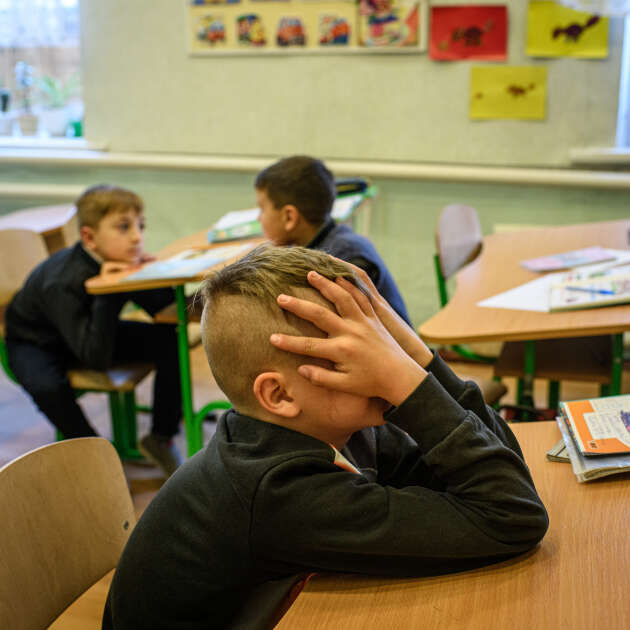 A Zolote, le 18 novembre. Sergueï, 7 ans, réagit en se cachant le visage lorsqu’il entend le mot « bombardement ».