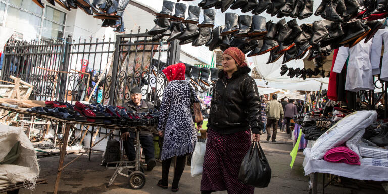 A shopper walks under boots hanging from footwear stalls at Chorsu Bazaar in Tashkent, Uzbekistan, on March 2, 2018. Uzbekistan knows it has plenty of catching up to do after sitting out much of the economic transformation that's swept across the former Soviet Union during more than two decades since the end of communism. Rapid-fire reforms have followed the death of long-time ruler Islam Karimov in 2016, with President Shavkat Mirziyoev lifting currency controls and easing some travel restrictions. Photograph: Taylor Weidman/Bloomberg via Getty Images