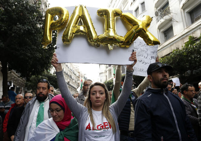 Le mot « paix » au milieu des manifestants contre le gouvernement, à Alger, le 27 décembre.