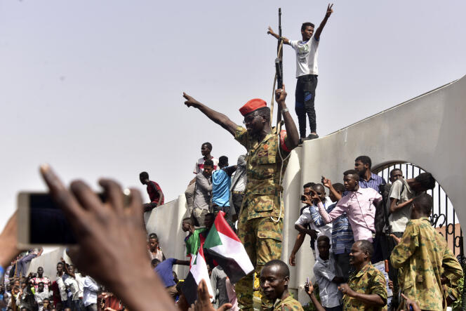 Des soldats et civils soudanais fêtent la chute d’Omar al-Bachir, à Khartoum, le 11 avril 2019.