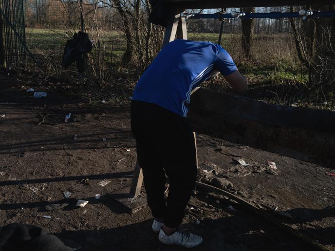 Un jeune Kurde se lave les cheveux au seul point d’eau mis à disposition des personnes migrantes, à Grande Synthe, le 30 décembre 2019.