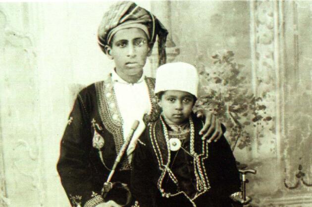 Le sultan Qabous Ben Saïd Al-Saïd au cours de sa jeunesse, sur les genoux de son père, le sultan Saïd Ben Tamour (photo non datée).