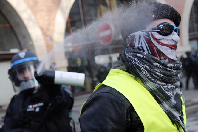 Un policier pulvérise du gaz lacrymogène sur un manifestant ayant revêtu un gilet jaune lors d’une manifestation contre la réforme des retraites, le 11 janvier 2020, à Paris.