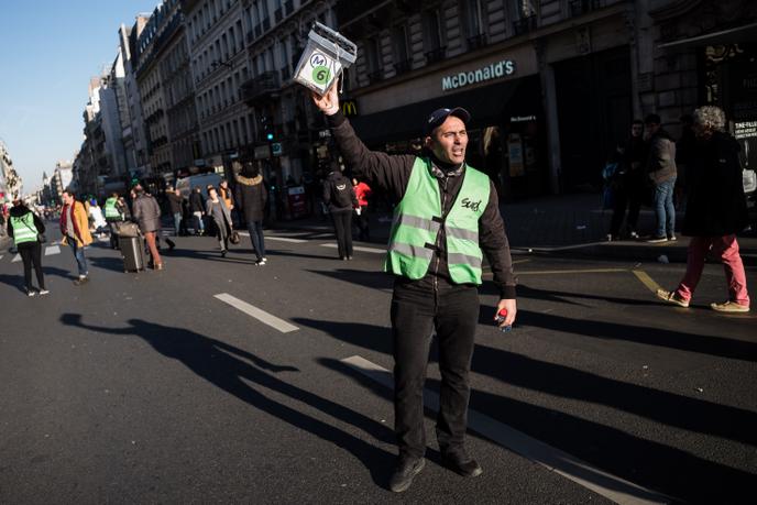 Roberto, un conducteur RATP de la ligne 6, tend une caisse de grève sur le trajet de la manifestation parisienne du 16 janvier.