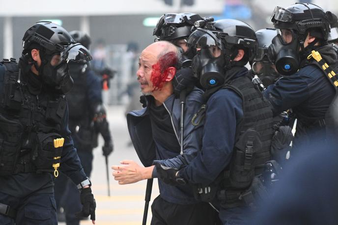 La police interpelle un homme blessé après que les forces de l’ordre ont dispersé une foule rassemblée au Chater Garden à Hongkong le 19 janvier 2020.
