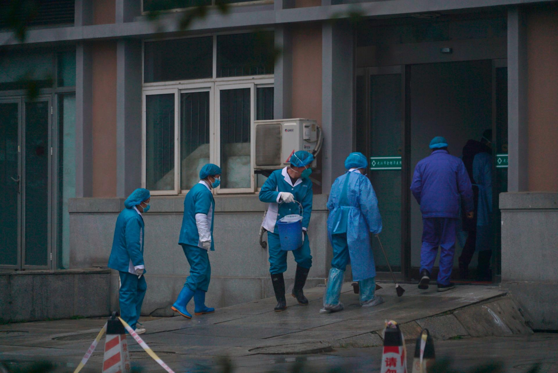 Des employés de l’hôpital nettoient l’entrée des urgences, à Wuhan, le 22 janvier