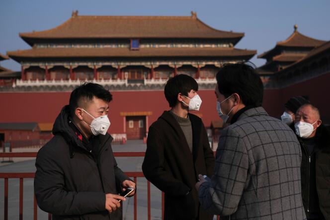 Des hommes portent des masques de protection à Pékin, le 25 janvier.
