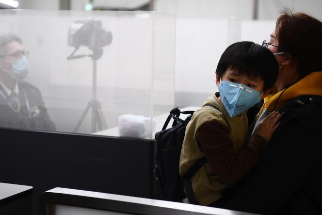 Des passagers en provenance de Wuhan passent par un poste de contrôle sanitaire à l’aéroport de Narita, près de Tokyo, le 23 janvier.