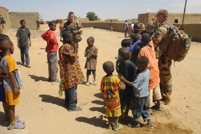 Des enfants et des soldats français de l’opération « Barkhane » à In-Tillit, dans le nord-est du Mali, en novembre 2017.