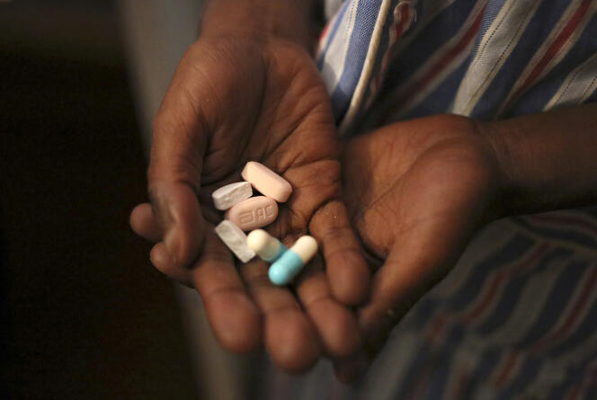Une fillette de 9 ans atteinte du VIH montre les différentes pillules de son traitement antirétroviral, à Johannesburg, en novembre 2014.