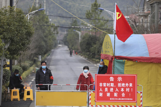 Des volontaires sur un barrage routier dans le village de Hangzhou, dans la province du Zhejiang, àl’est de la Chine, lundi 3 février.