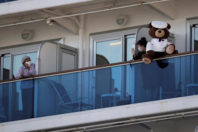 Deux passagères se saluent depuis leur cabine sur le « Diamond Princess », dans le port de Yokohama, le 11 février.