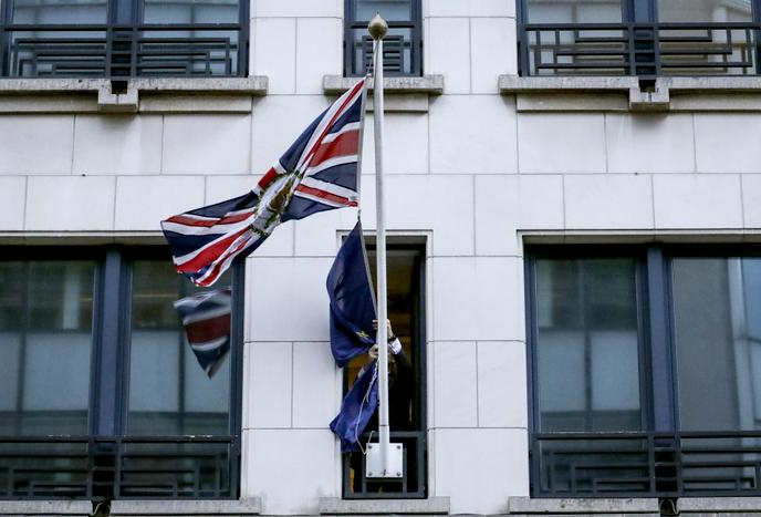 Un membre du protocole enlève le drapeau de l’Union européenne devant l’ancienne représentation permanente du Royaume-Uni à Bruxelles, le 31 janvier.
