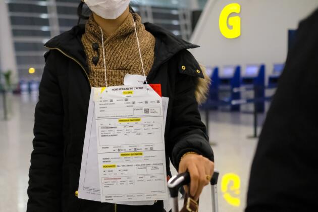 2 février. Les évacués portent sur eux leur fiche d’identification avant d’embarquer.  Les masques ne sont abaissés qu’au passage des contrôles pour répondre aux questions de la sécurité.
