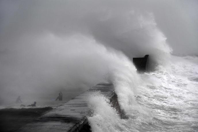 Surfers swim during Storm Dennis at Plobannalec-Lesconil Sunday February 16.