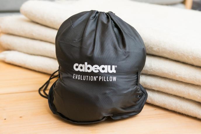 Le coussin Cabeau est réduit au tiers de sa taille dans la housse et est fixé avec du velcro.