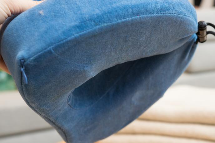 Le coussin en velours de l'oreiller Cabeau est retiré et entre dans la machine.
