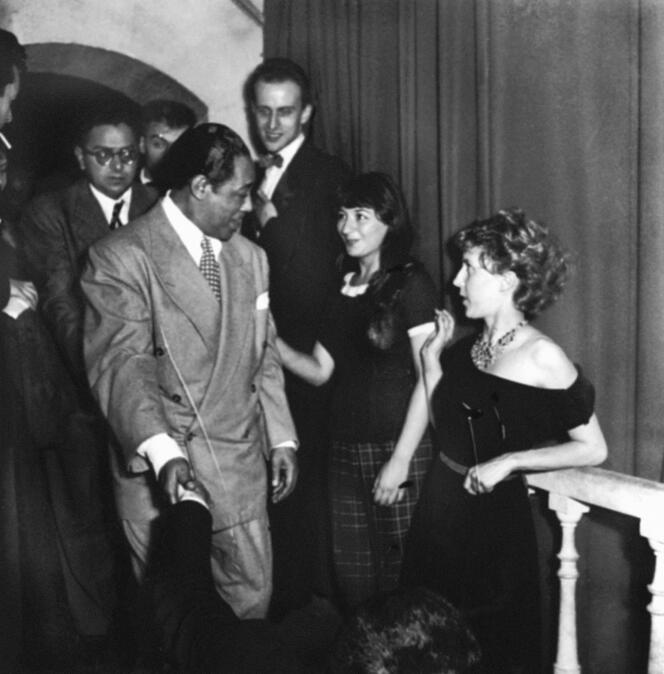 Le pianiste et compositeur de jazz américain Duke Ellington est félicité par, de gauche à droite, Boris Vian, Juliette Gréco et Anne-Marie Cazalis au Club Saint-Germain-des-Prés, à Paris, à l’occasion d’un gala organisé en son honneur, le 19 juillet 1948. Derrière eux, le pianiste Jacques Diéval.
