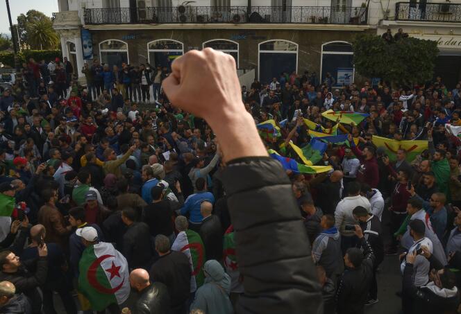 Des étudiants brandissent les drapeaux berbère et algérien, lors de l’un des rassemblements hebdomadaires du Hirak, à Alger, le 21 février 2020.