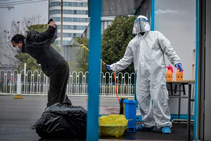 Un homme qui s’est remis du SARS-CoV-2, virus responsable de Covid-19, est désinfecté par un membre du personnel médical avant de quitter l’hôpital de Wuhan, dans la province centrale du Hubei, en Chine, le 22 février 2020.