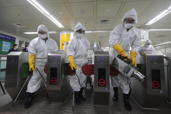 Des employés de santé pulvérisent du désinfectant dans une station de métro de Séoul, en Corée du Sud, vendredi 28 février 2020.