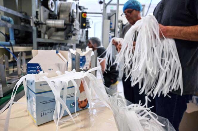 Des employés emballent des masques de protection sur une chaîne de montage de l’usine Valmy à Mably (Loire), le 28 février 2020, où le nombre de salariés a triplé avec la propagation de la maladie Covid-19 en Europe.