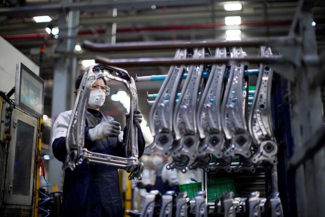 Un employé d’une usine de Shanghaï équipé d’un masque, le 24 février.