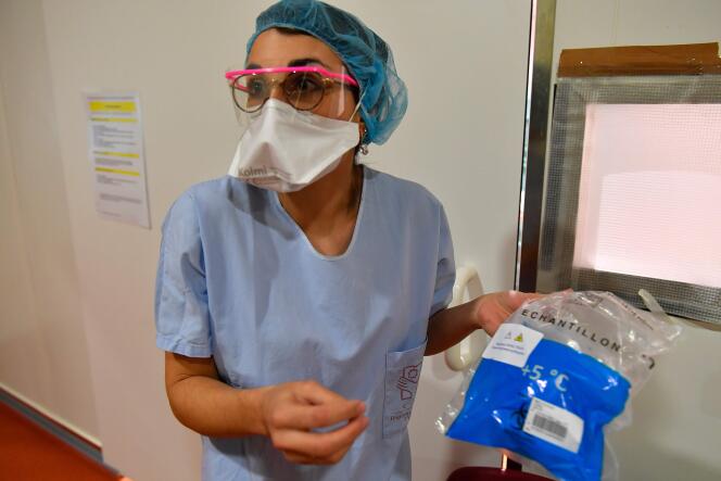 Une infirmière du CHU de Bordeaux transporte des échantilons prélevés sur des patients, le 9 mars.