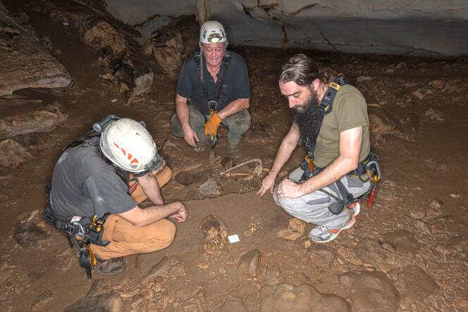 De gauche à droite : les chercheurs Sébastien Villote, Richard Oslisly et Sacha Kacki devant les restes d’un crâne dans la grotte d’Iroungou, au Gabon, le 3 mars 2020.
