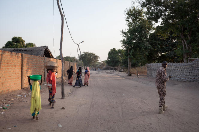 Des femmes et un combattant d’un groupe armé marchent sur une route à Birao, dans le nord de la Centrafrique, en décembre 2017.