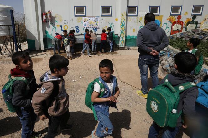 Des réfugiés syriens lors d’une campagne de sensibilisation sur le coronavirus au camp de Zaatari (Jordanie), le 11 mars.