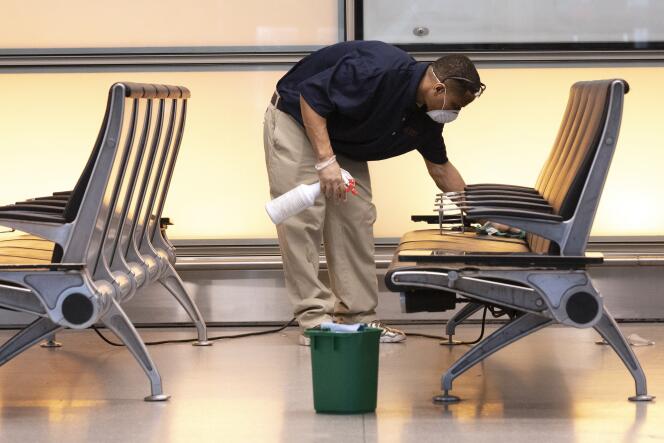 Un homme désinfecte une salle d’attente à l’aéroport international de Boston (Massachusetts), aux Etats-Unis,le 13 mars.