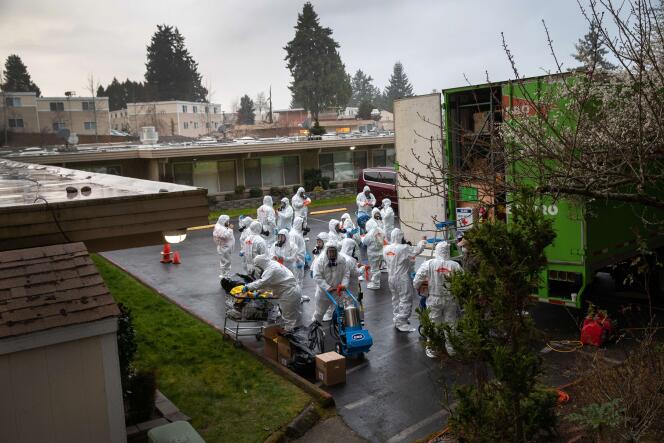 Une équipe de nettoyage s’apprête à entrer dans le Life Care Center, où a été comptabilisé le plus grand nombre de décès dû au coronavirus de tous les Etats-Unis, le 12 mars 2020, à Kirkland, près de Seattle (Etat de Washington).