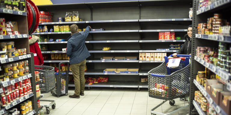 A man picks up some pasta on empty shelf in a supermarket, Friday March, 13, 2020 in Strasbourg eastern France. For most people, the new coronavirus causes only mild or moderate symptoms. For some it can cause more severe illness, especially in older adults and people with existing health problems. (AP Photo/Jean-Francois Badias)