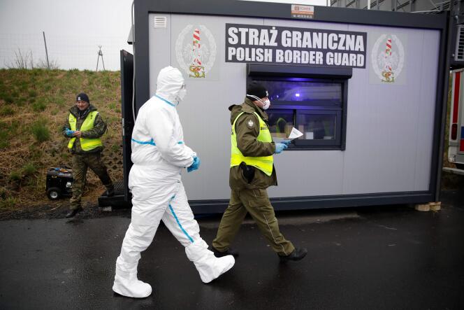 Les autorités polonaises équipées pour effectuer des contrôles sanitaires sur les passagers des véhicules, à la frontière avec l’Allemagne, le 9 mars.