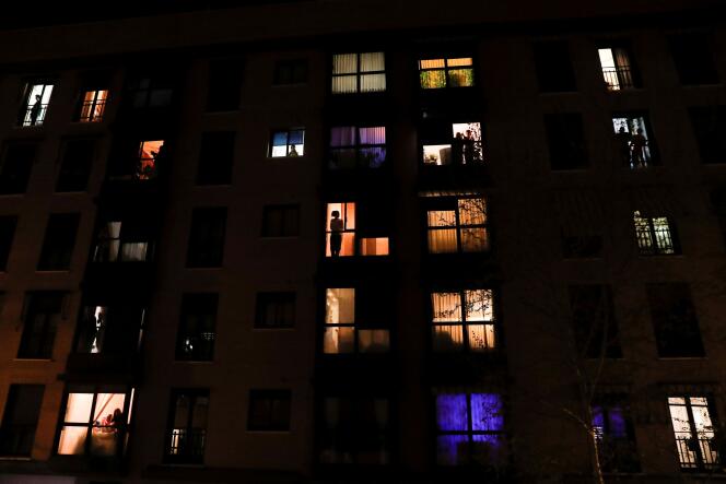 Les résidents confinés applaudissent depuis leurs fenêtres pour montrer leur reconnaissance au personnel soignant, à Madrid, le 14 mars.
